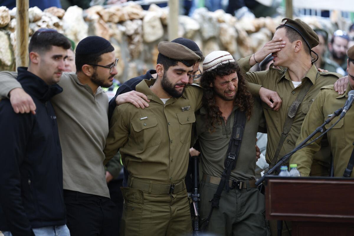 Israeli soldiers grieve during a funeral