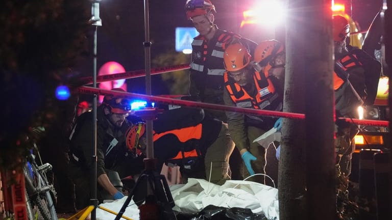 Israeli first responders remove the body of a person from...