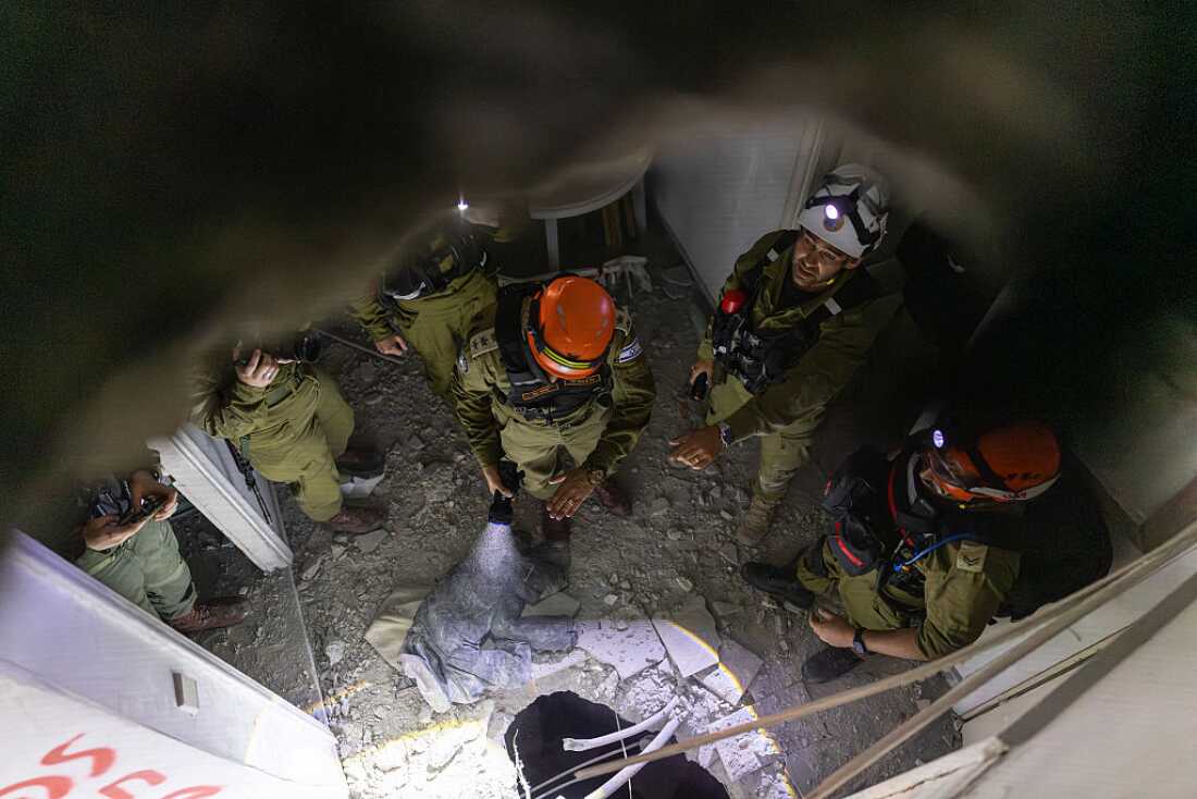 Members of Israel's Home Front Command (HFC) investigate a building damaged by a strike in Tel Aviv on March 28, 2026. On the evening of March 27, the Israeli army reported missiles fired by Iran at Israel.