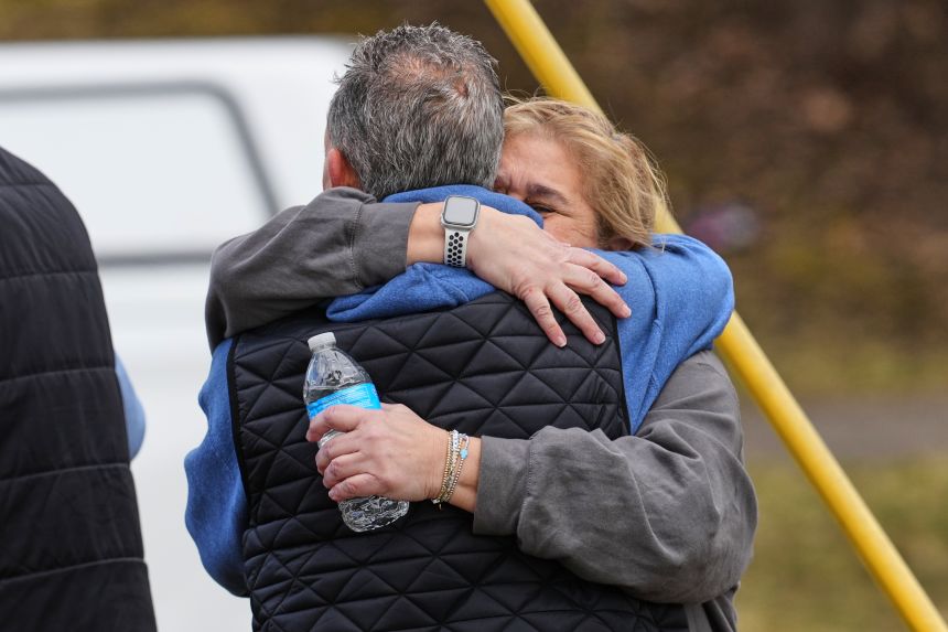 People embrace as law enforcement escort families away from the Temple Israel synagogue in West Bloomfield Township, Michigan, on March 12.