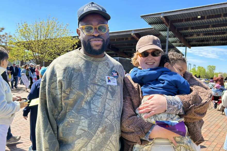Nick and Shannon Murray stand in Railroad Park at the No Kings rally as Shannon Murray holds their 19-month-old son.