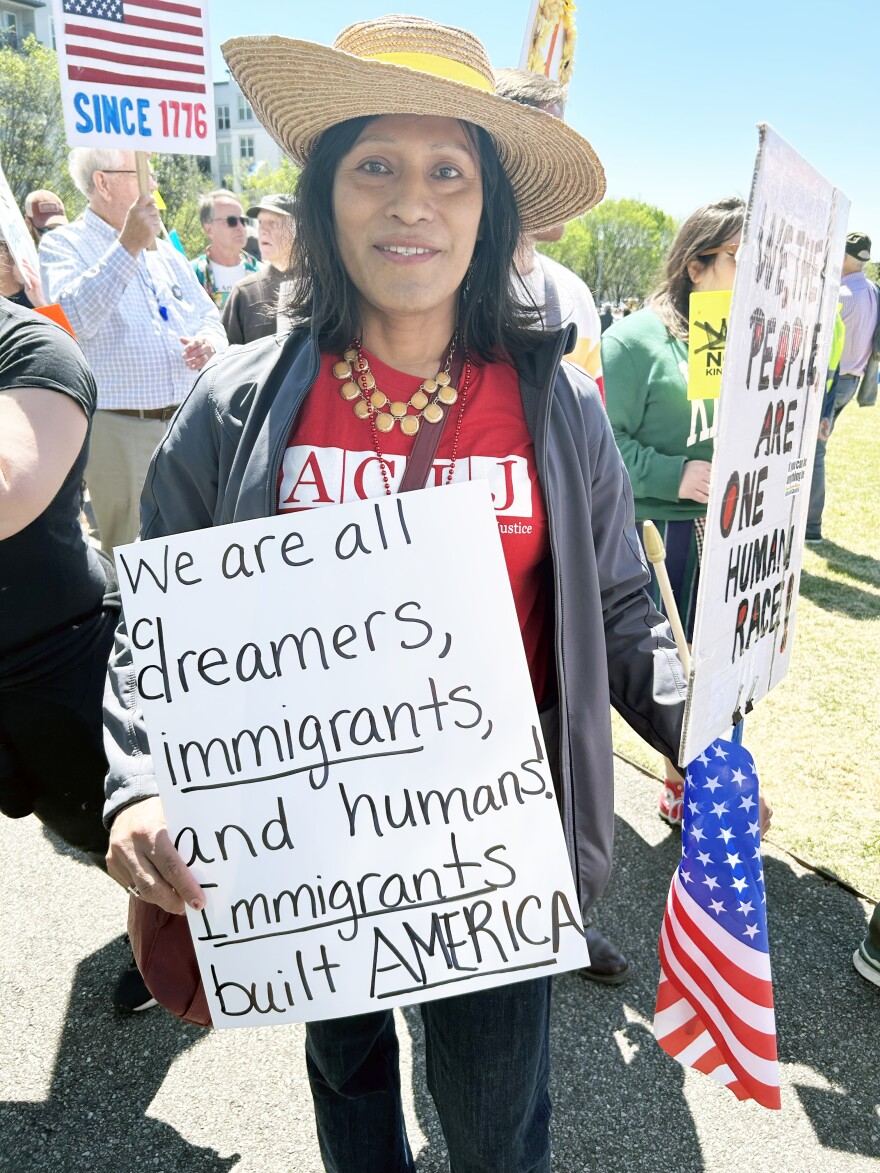 Issa Sanz holds signs at the No Kings protest in Birmingham.