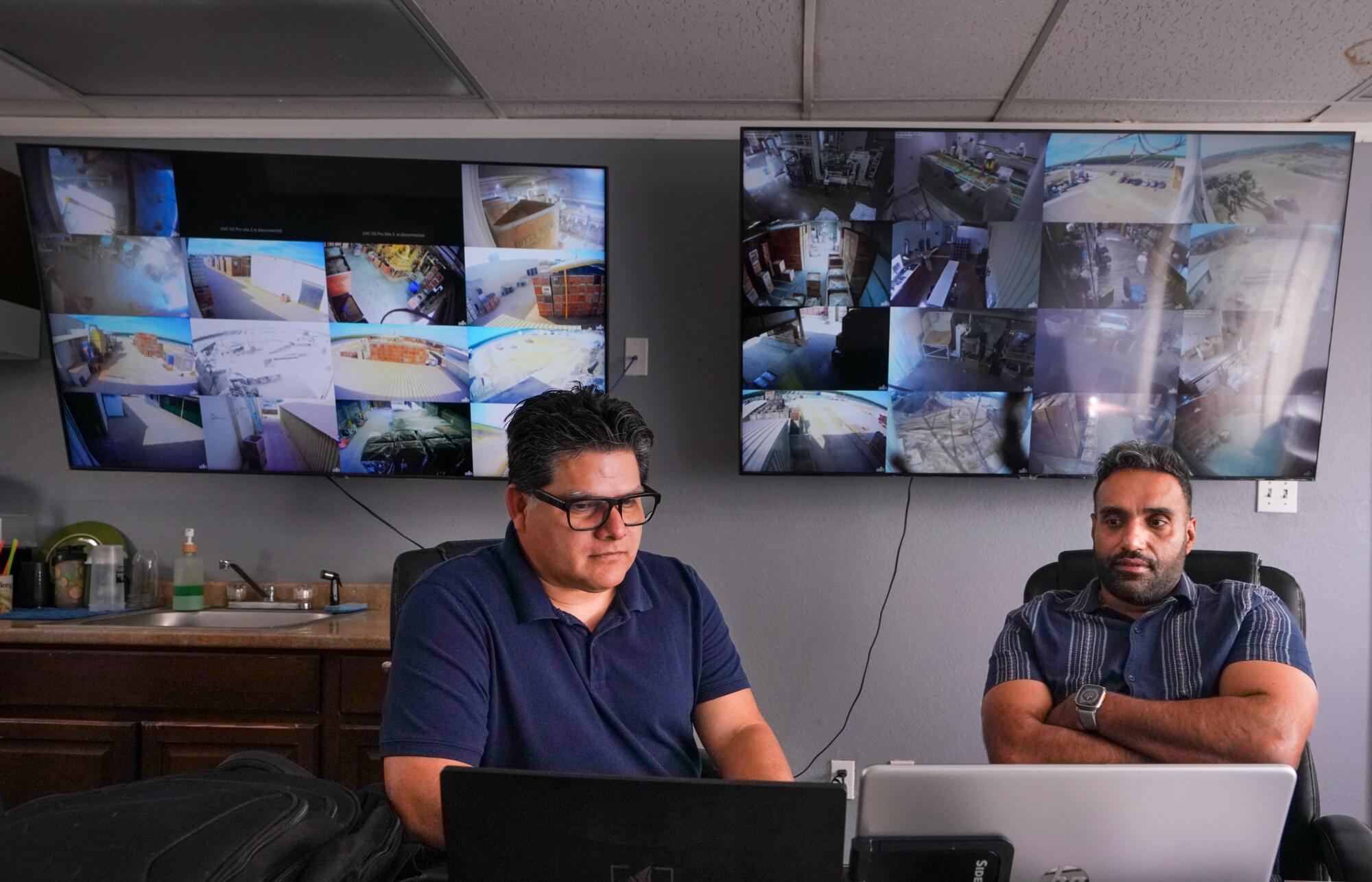 two men look at computers in company offices