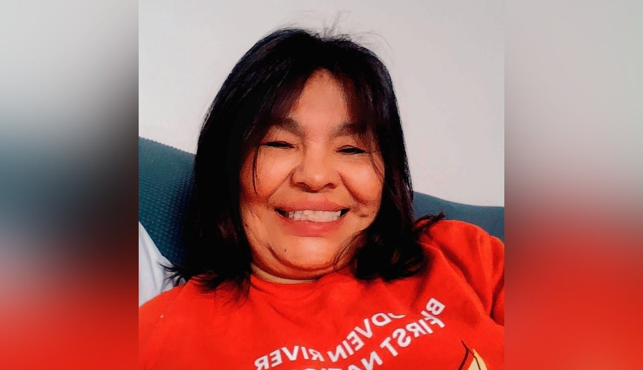 Woman with dark hair smiles and wears a red t-shirt