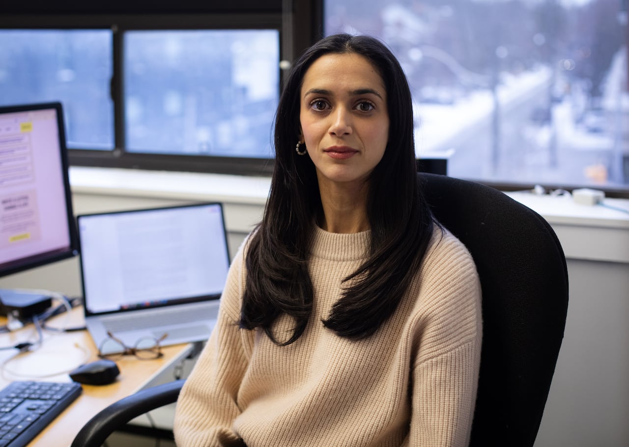 A human rights lawyer sits at her desk with a city street visible through her window.