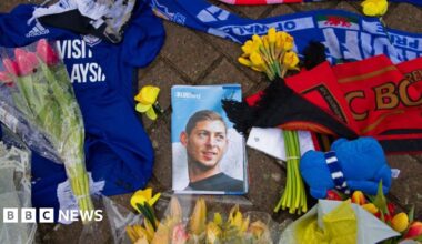 Flowers and football tops and scarves on the ground, surrounding a photograph of a young man, on the front of a magazine entitled "Bluebird".