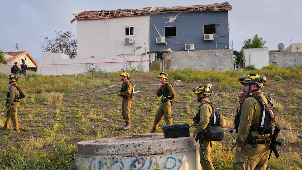 Israeli security forces work at the site of an Iranian missile strike, in Beersheba, southern...