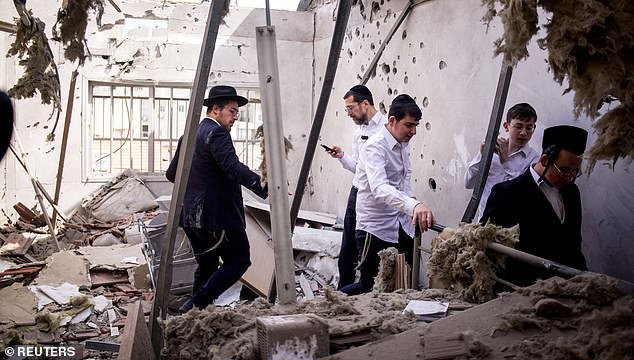 Ultraorthodox Jews check on a residential building where damage was caused following the launch of barrages of Iranian missiles towards Israel, amid the U.S.-Israeli conflict with Iran, in Bnei Brak Israel, March 31, 2026. REUTERS/Itai Ron ISRAEL OUT. NO COMMERCIAL OR EDITORIAL SALES IN ISRAEL