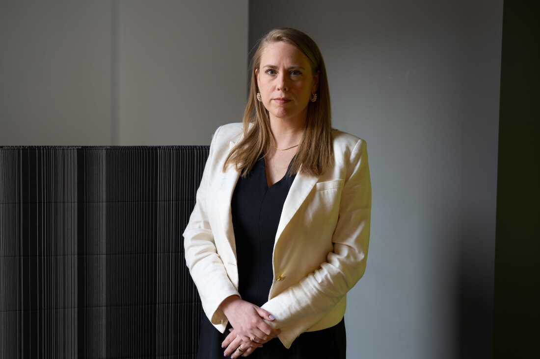 Andrea Lucas stands near a black-and-gray striped wall.