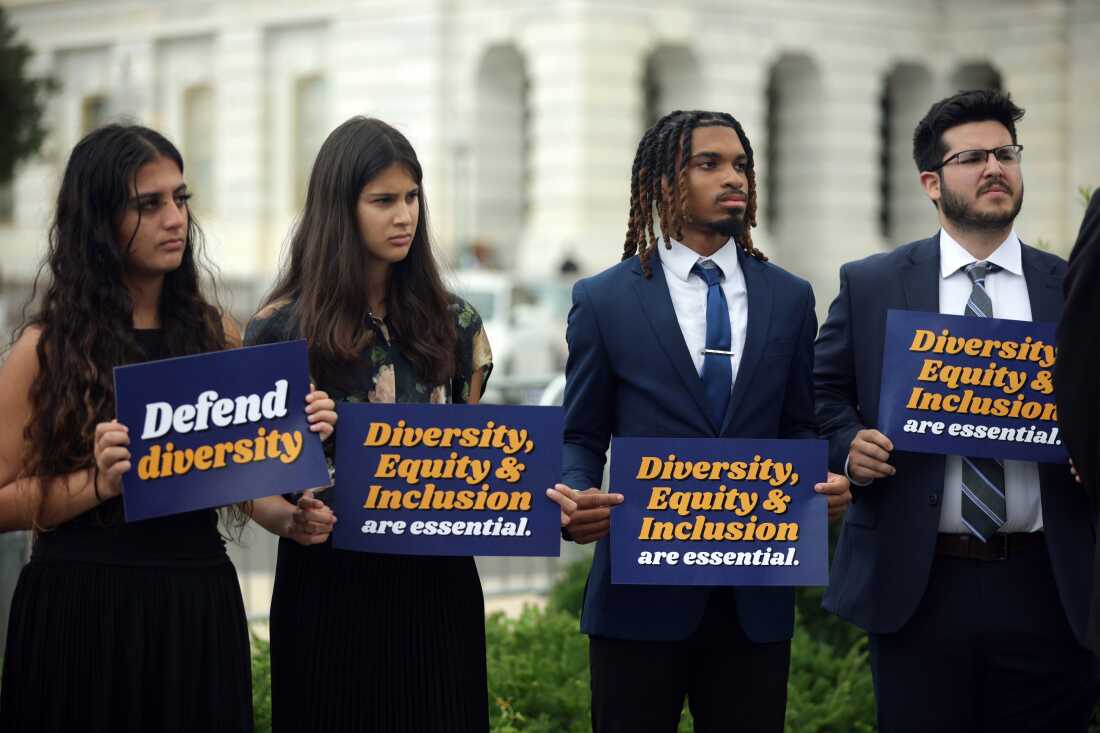 Activists hold signs during a news conference held by Representative Ayanna Pressley on diversity, equity, and inclusion initiatives, outside the U.S. Capitol on July 23, 2025.