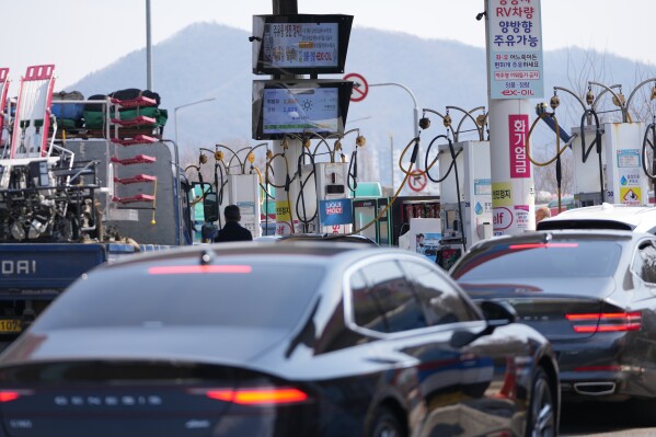 A man, center, fuels up a vehicle at a gas station in Seoul, South Korea, Tuesday, March 10, 2026. (AP Photo/Lee Jin-man)