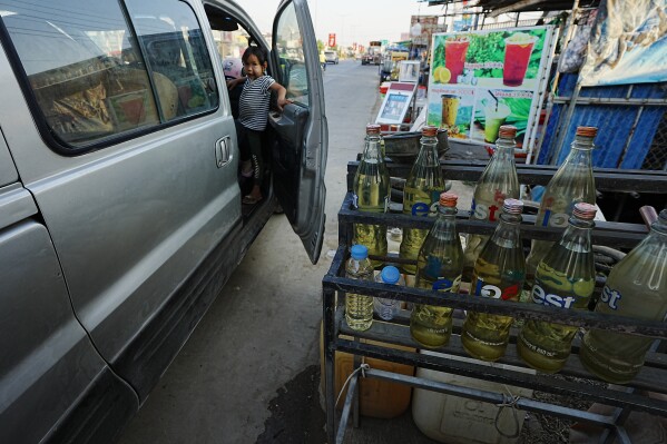 Gasoline bottles are displayed at a vendor's shop in Phnom Penh, Cambodia, Monday, March 30, 2026. (AP Photo/Heng Sinith)