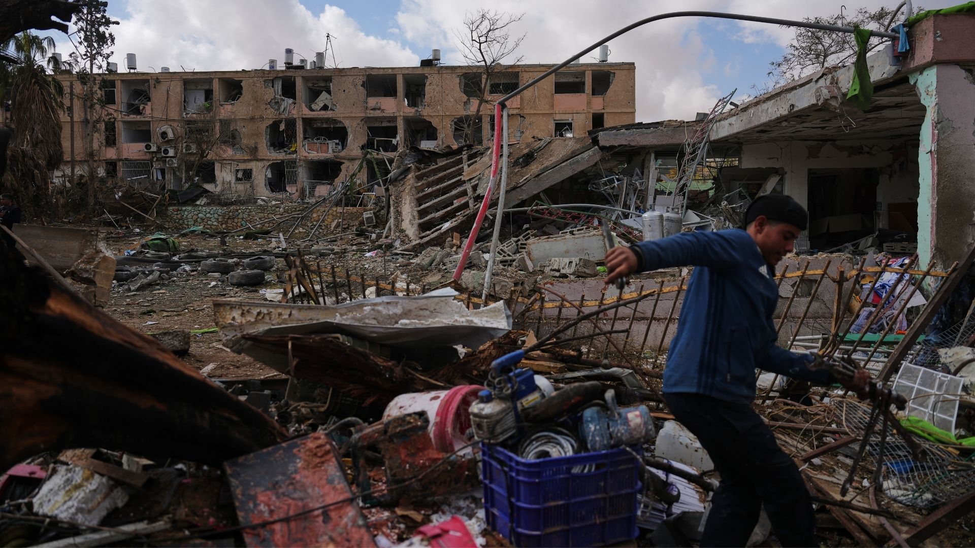 People survey a site that was struck by an Iranian missile in Dimona, southern Israel, Sunday, March 22, 2026.