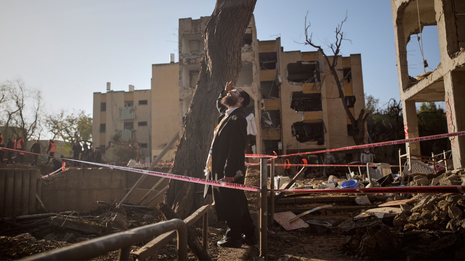 A man looks at residential buildings damaged by an Iranian missile strike in Arad, southern Israel, Sunday, March 22, 2026.