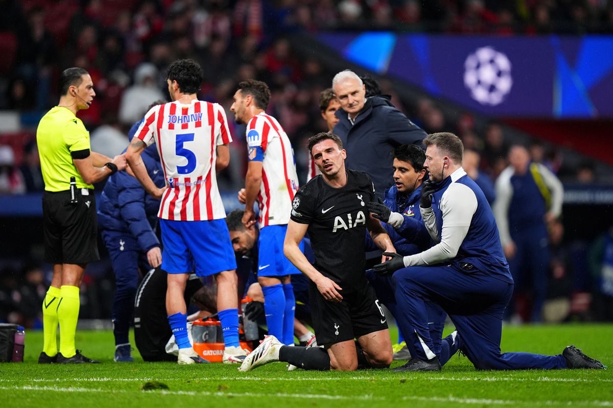 Joao Palhinha of Tottenham Hotspur receives medical treatment after clashing heads with his teammate Cristian Romero during the UEFA Champions League 2025/26 Round of 16 First Leg match between  Atletico de Madrid and Tottenham Hotspur FC at Estadio Civitas Metropolitano on March 10, 2026 in Madrid, Spain