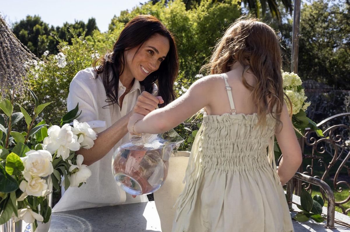Meghan Markle with daughter Lilibet arranging flowers outside