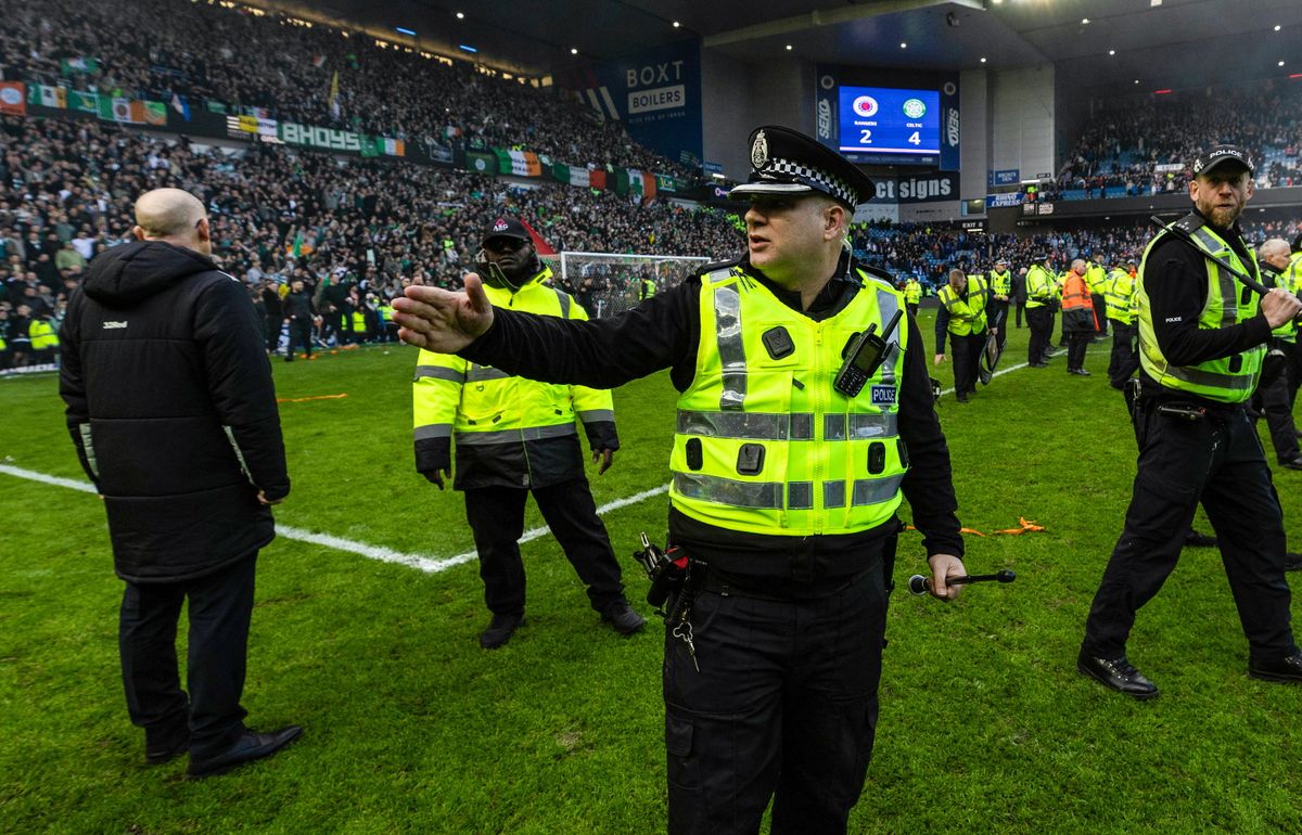A police officer as fans storm the pitch 