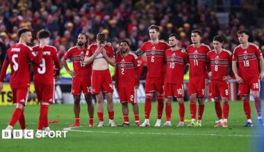 Wales players stand in a line during the penalty shootout with Neco Williams being comforted