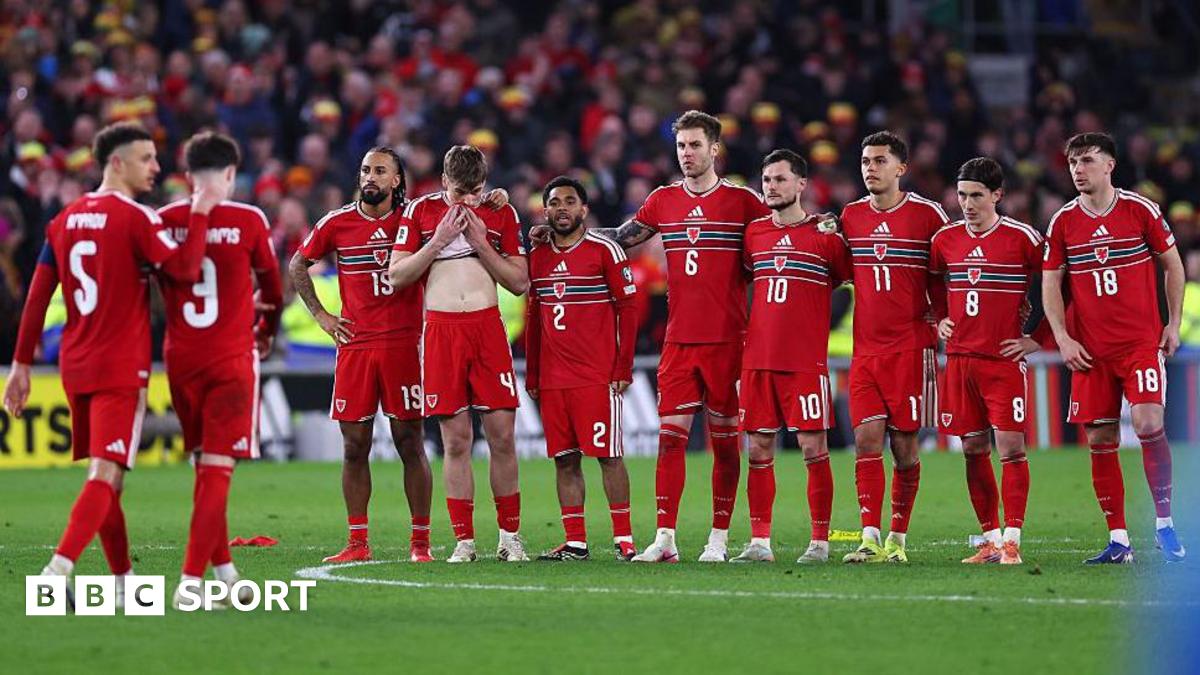 Wales players stand in a line during the penalty shootout with Neco Williams being comforted