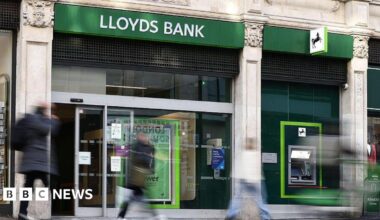 People walk past a Lloyds Bank branch on a UK high street.