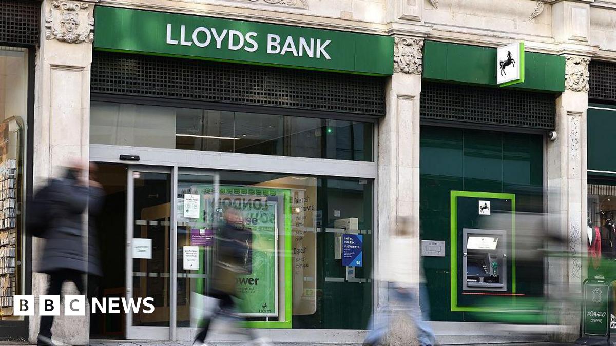 People walk past a Lloyds Bank branch on a UK high street.