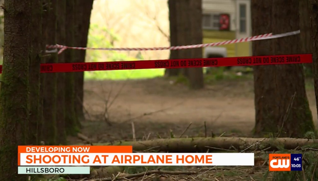 Crime scene tape reading "CRIME SCENE DO NOT CROSS" strung between trees near a house, with a news chyron at the bottom reporting "SHOOTING AT AIRPLANE HOME".