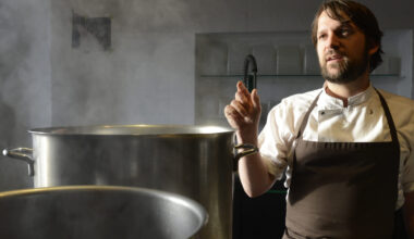 Redzepi, chef and co-owner of the restaurant Noma, talks with his employees in a test kitchen in his restaurant in Copenhagen