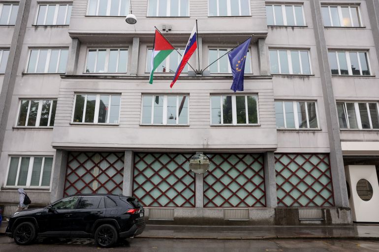 A Palestinian flag flies next to a Slovenian and a European Union flag, at the government building in Ljubljana, Slovenia