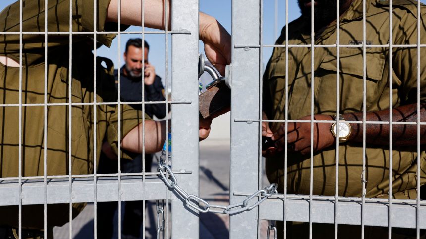 Soldiers lock a gate from inside the Sde Teiman detention facility in July 2024.