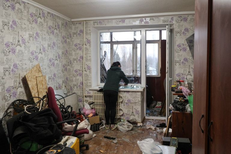 A resident removes broken window glass inside her apartment damaged by a Russian drone strike on Thursday, amid Russia's attack on Ukraine, in Kharkiv, Ukraine February 26, 2026. REUTERS/Vyacheslav Madiyevskyy TPX IMAGES OF THE DAY