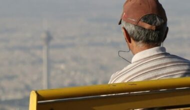 Man in a cap and white shirt looking over Tehran