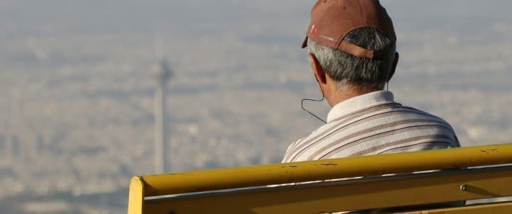 Man in a cap and white shirt looking over Tehran