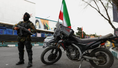 A member of a police force stands guard on a street, amid the U.S.-Israeli conflict with Iran, in Tehran