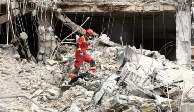 Emergency personnel work at the site of a strike on a residential building, in Tehran