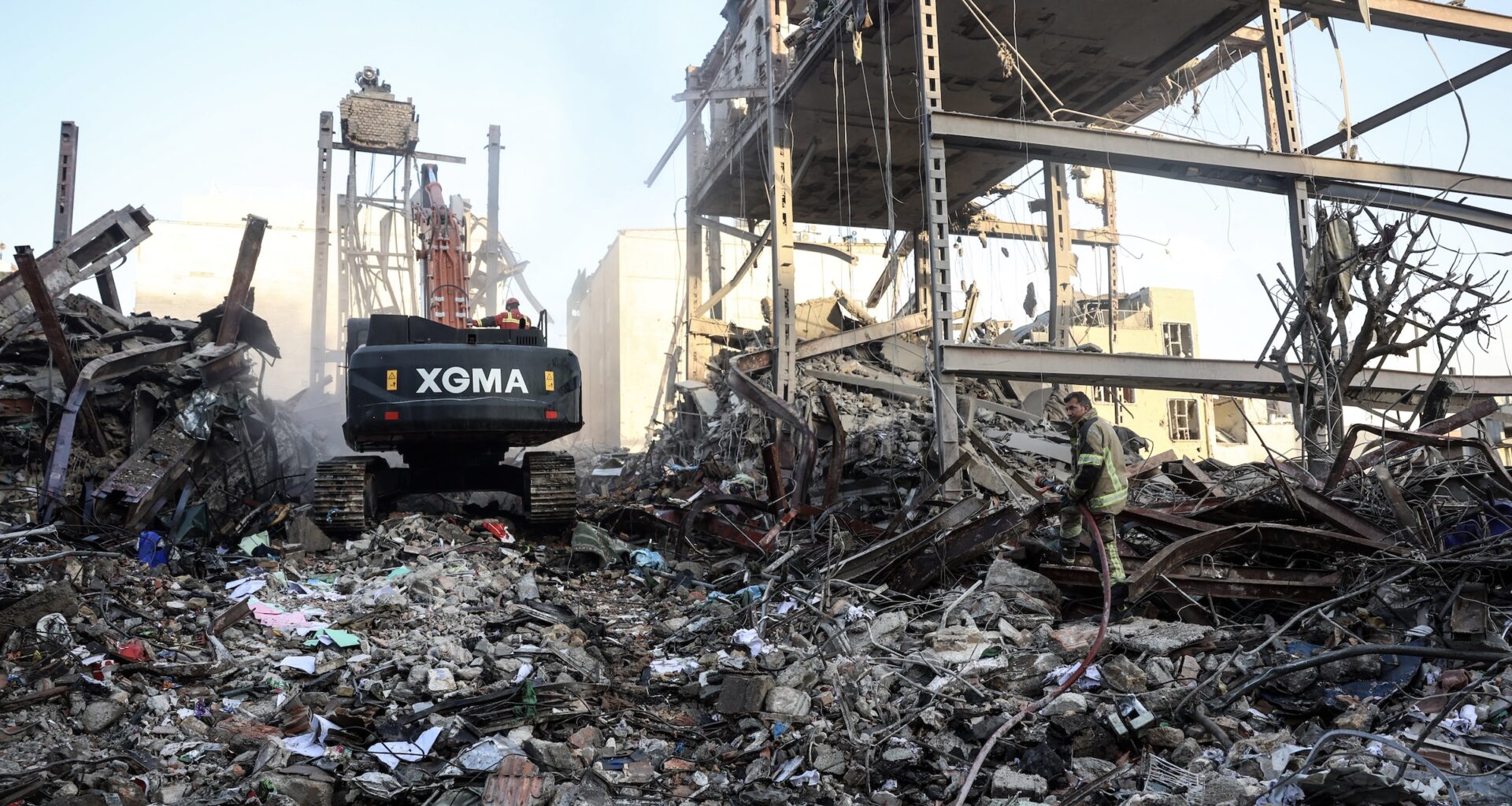 A firefighter stands on the rubble of residential buildings near Niloufar square in Tehran during the ongoing joint U.S.-Israeli military campaign on Iran on March 2, 2026.