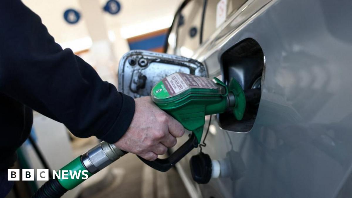 A motorist fills their car with unleaded fuel at a petrol station.