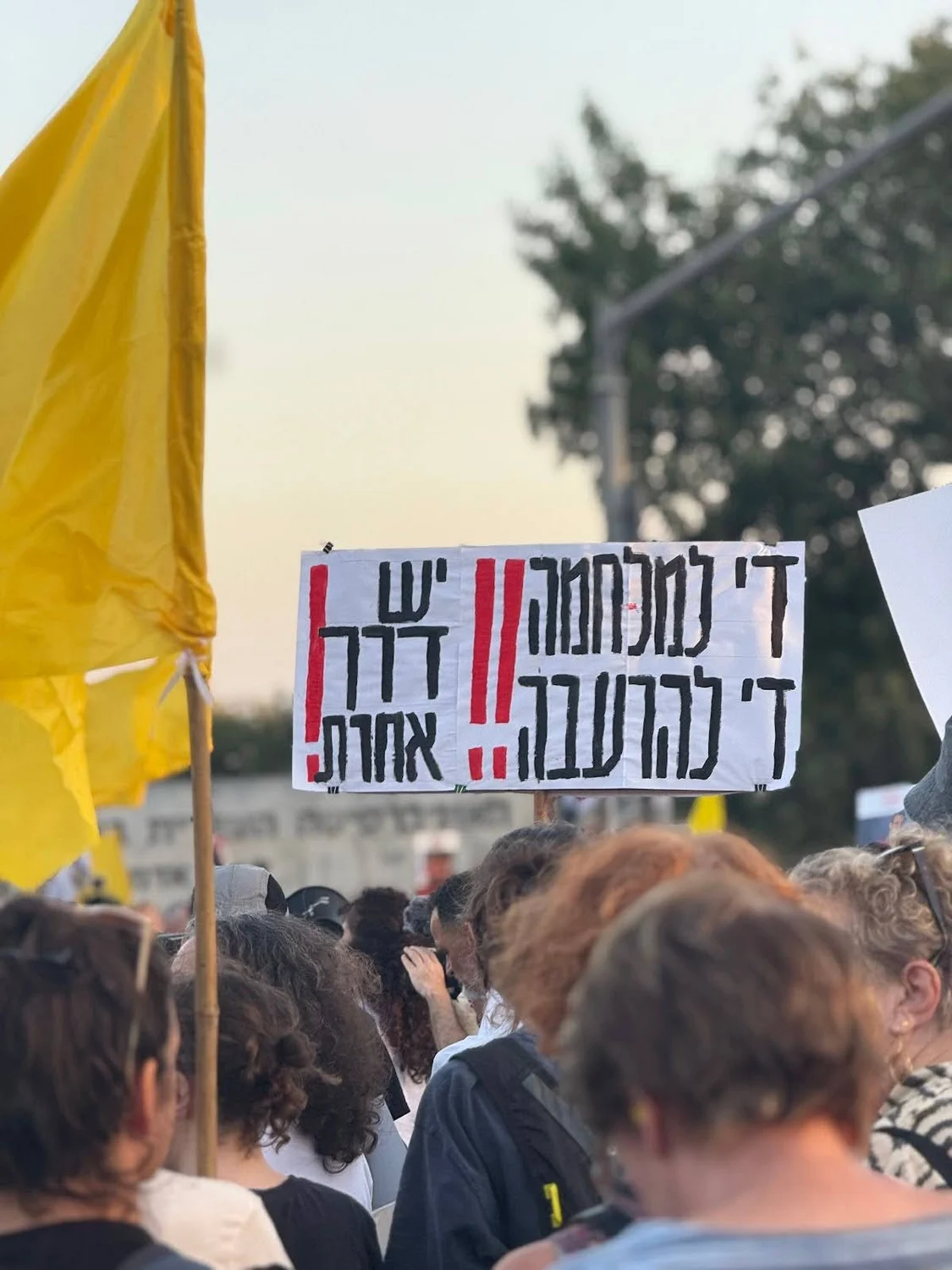 A sign raised at a protest in Givat Ram, Jerusalem in August 2025. The sign translates to: "Enough to war! Enough to starvation! There is another way!"