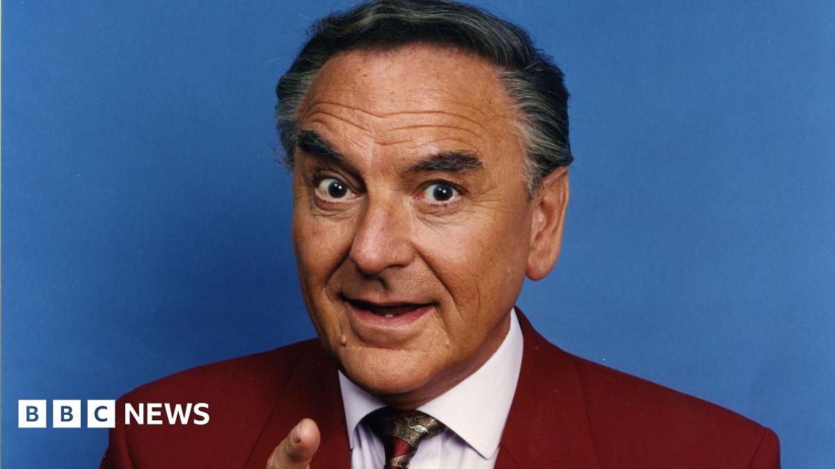 Bob Monkhouse in a suit pointing at the camera
