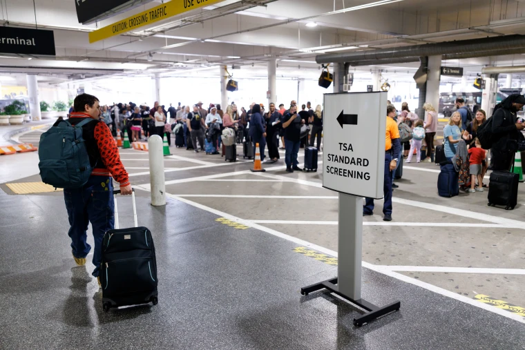 Travelers wait in line at a TSA checkpoint at William P. Hobby Airport in Houston, Texas, US, on Monday, March 9, 2026. 