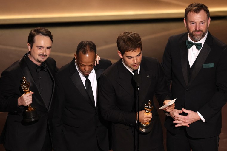 David Breschel, Mike Yung, Sam Davis and Jack Piatt accept the Oscar for best live-action short film for "The Singers."