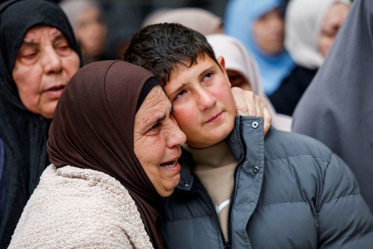 An elder woman embraces a Palestinian child, Khaled