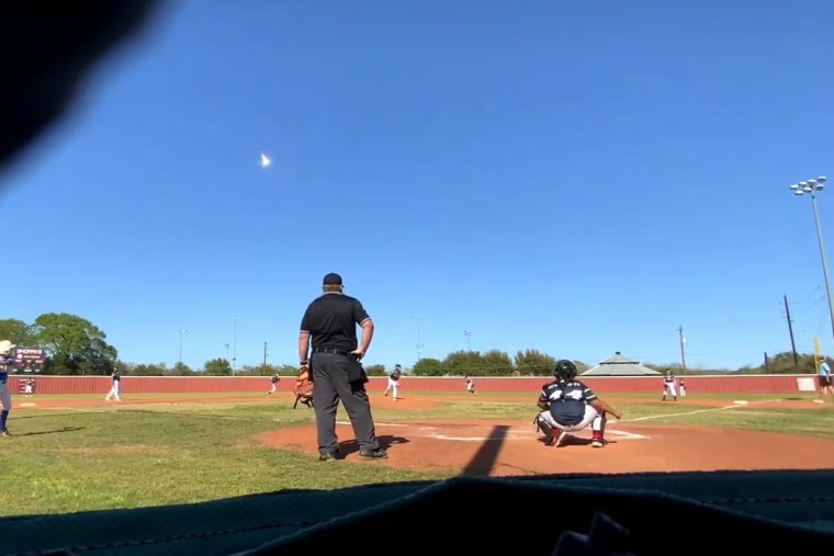A meteor flies through the sky during a baseball game