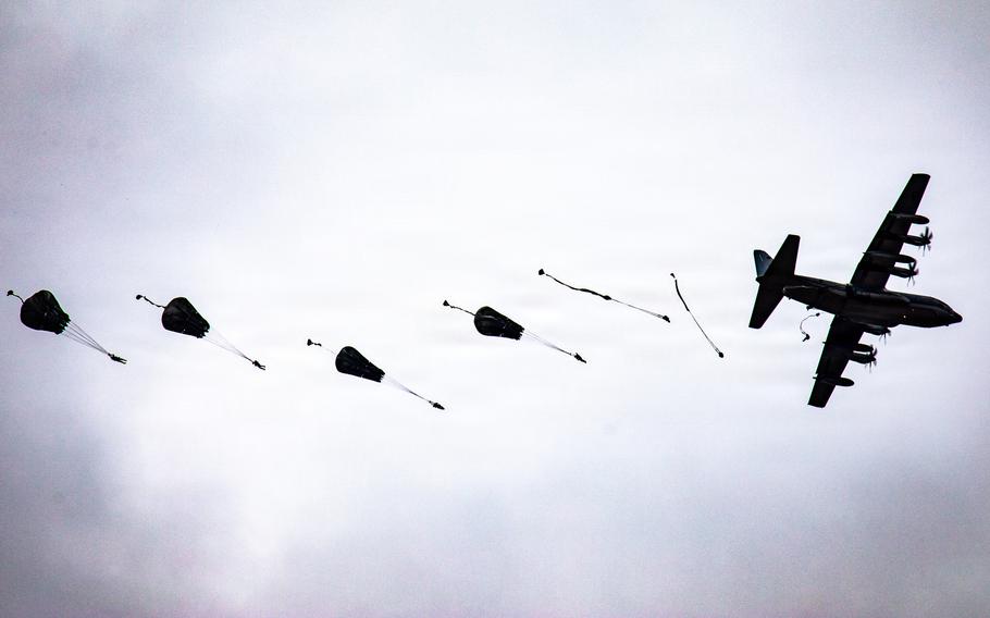 Paratroopers jump from a plane.