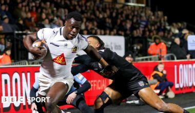Exeter winger Paul Brown-Bampoe (left) with the ball in his right hand goes through an attempted tackle from Elliott Obatoyinbo