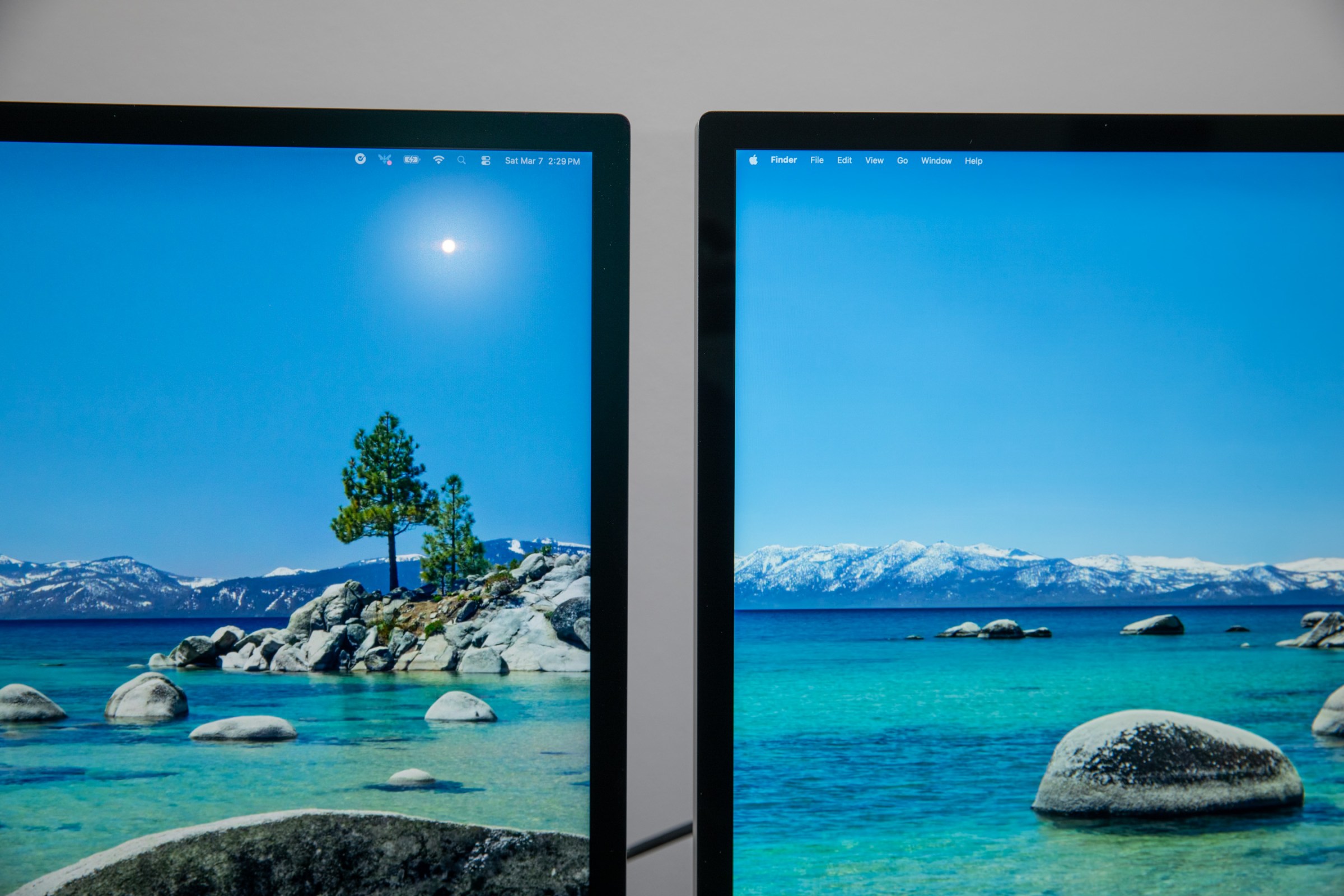 A closeup of the Apple Studio Display XDR and Studio Display screens with a reflection in the Studio Display XDR screen.