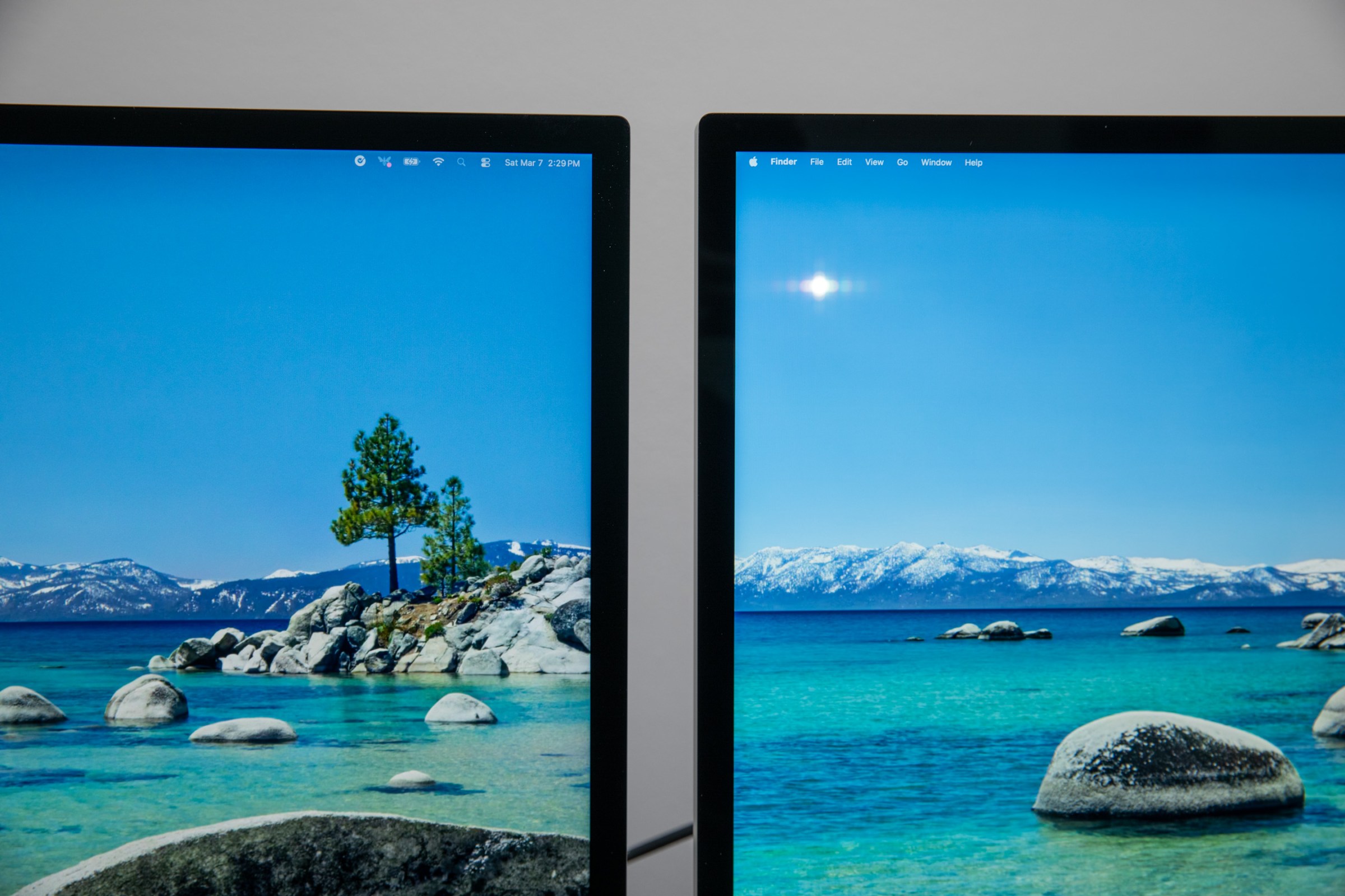 A closeup of the Apple Studio Display XDR and Studio Display screens with a reflection in the Studio Display screen.