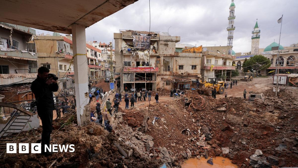 People inspect the damage where Israel's military carried out an airborne operation that dropped troops overnight, in the town of Nabi Chit.