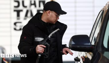 A man wearing a black cap and coat fills his tank at a petrol station in London, 29 March 2026.