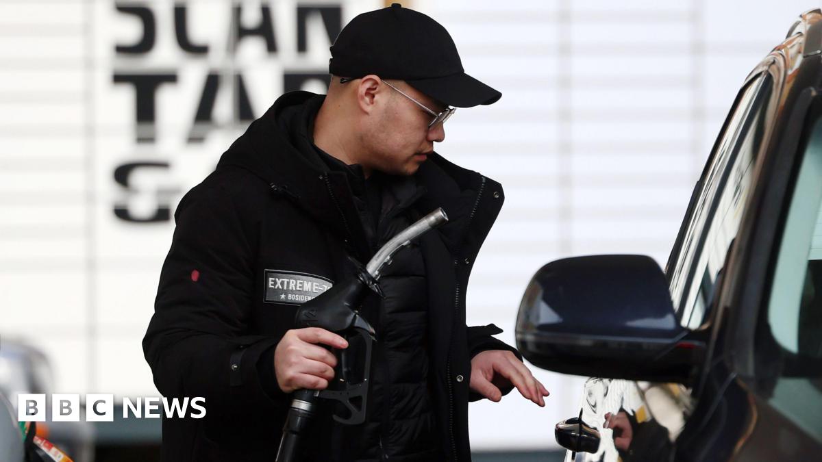 A man wearing a black cap and coat fills his tank at a petrol station in London, 29 March 2026.