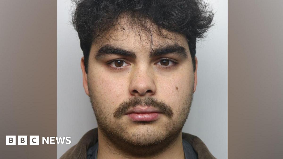 Kyran Smith mugshot. He has dark hair and dark stubble.